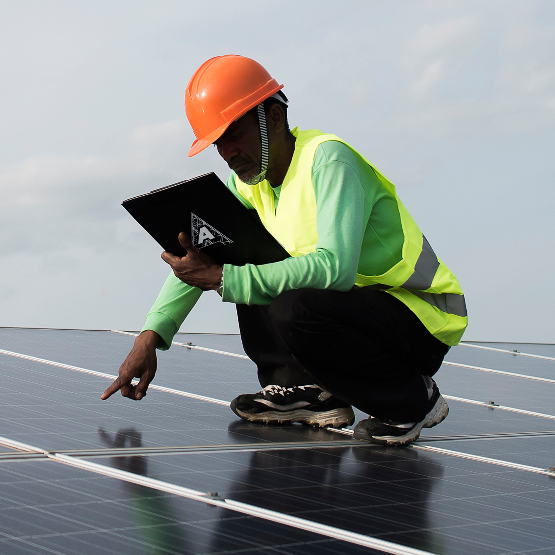 African american technician checks the maintenance of the solar panels. Group of three black engineers meeting at solar station.